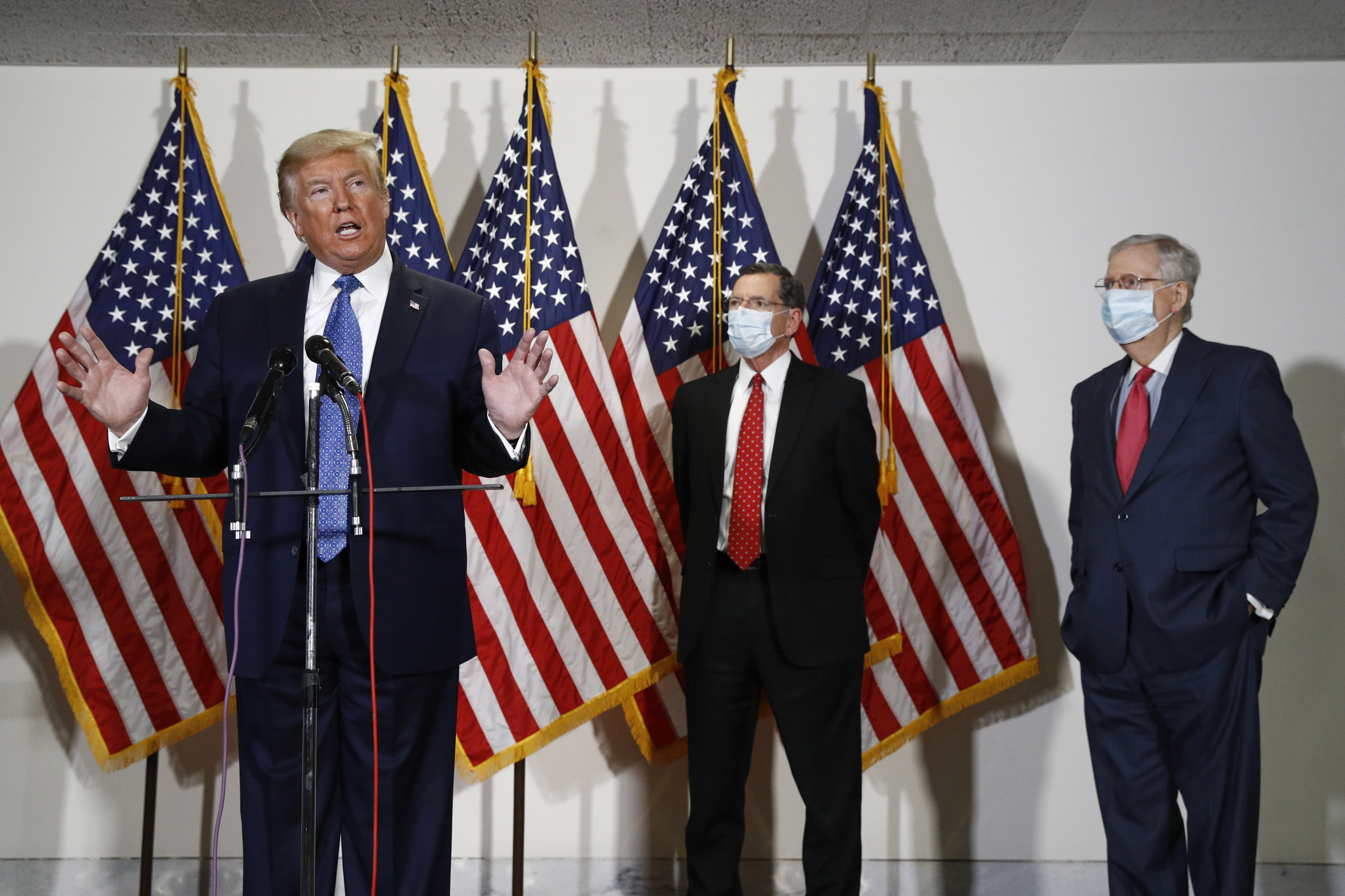 President Donald Trump speaks with reporters after meeting with Senate Republicans at their weekly luncheon on Capitol Hill in Washington, Tuesday, May 19, 2020. Standing behind Trump are Sen. John Barrasso, R-Wyo., second from right, and Senate Majority Leader Mitch McConnell of Ky. (AP Photo/Patrick Semansky)
