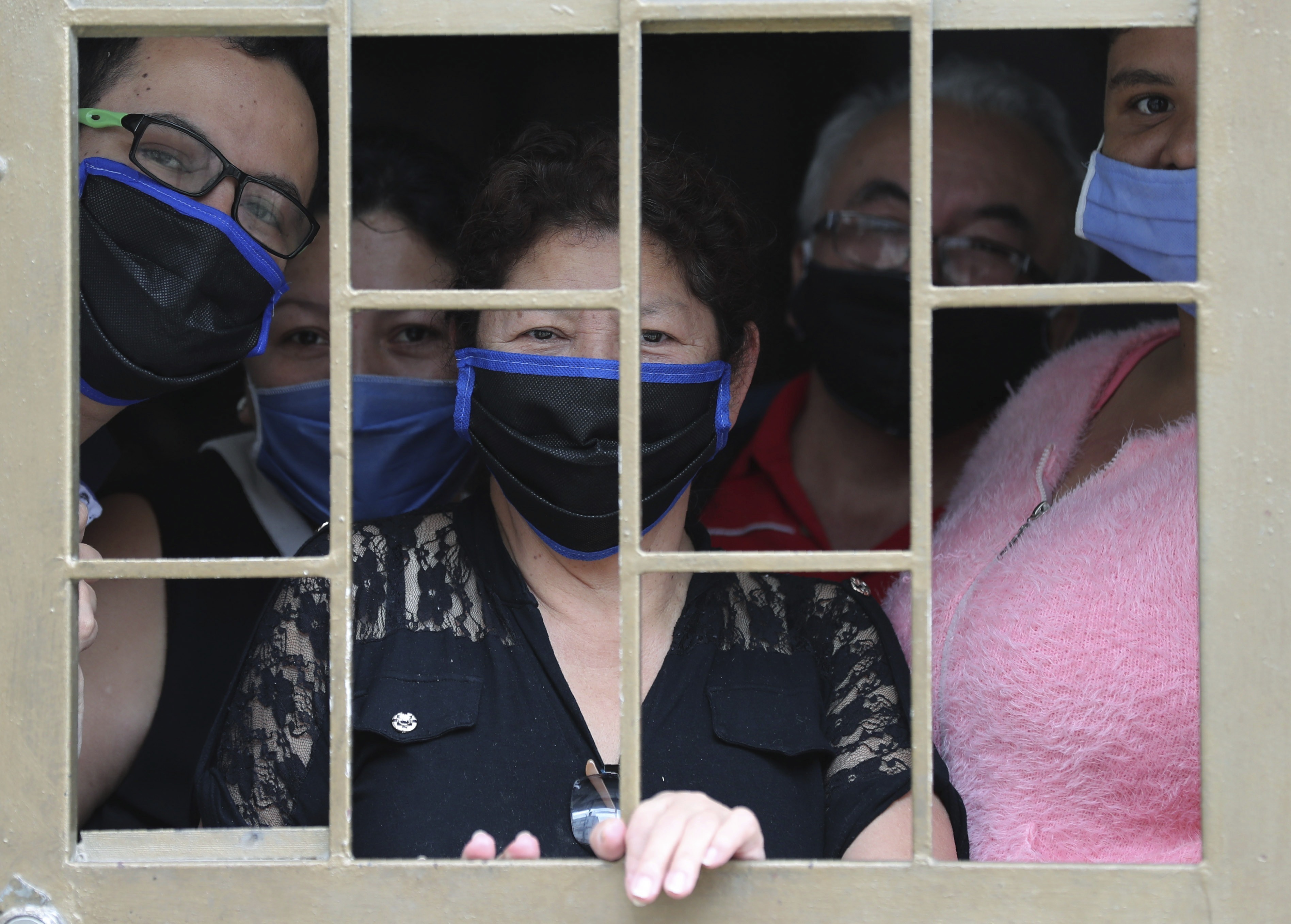 A family peers from the window of their home as they wait to receive boxes of free food, during a lockdown to curb the spread of the new coronavirus, in Bogota, Colombia, Monday, May 4, 2020. The U.N. World Food Program is warning that upward of at least 14 million people could go hungry in Latin America as the coronavirus pandemic rages on, shuttering people in their homes, drying up work and crippling the economy. Photo: AP