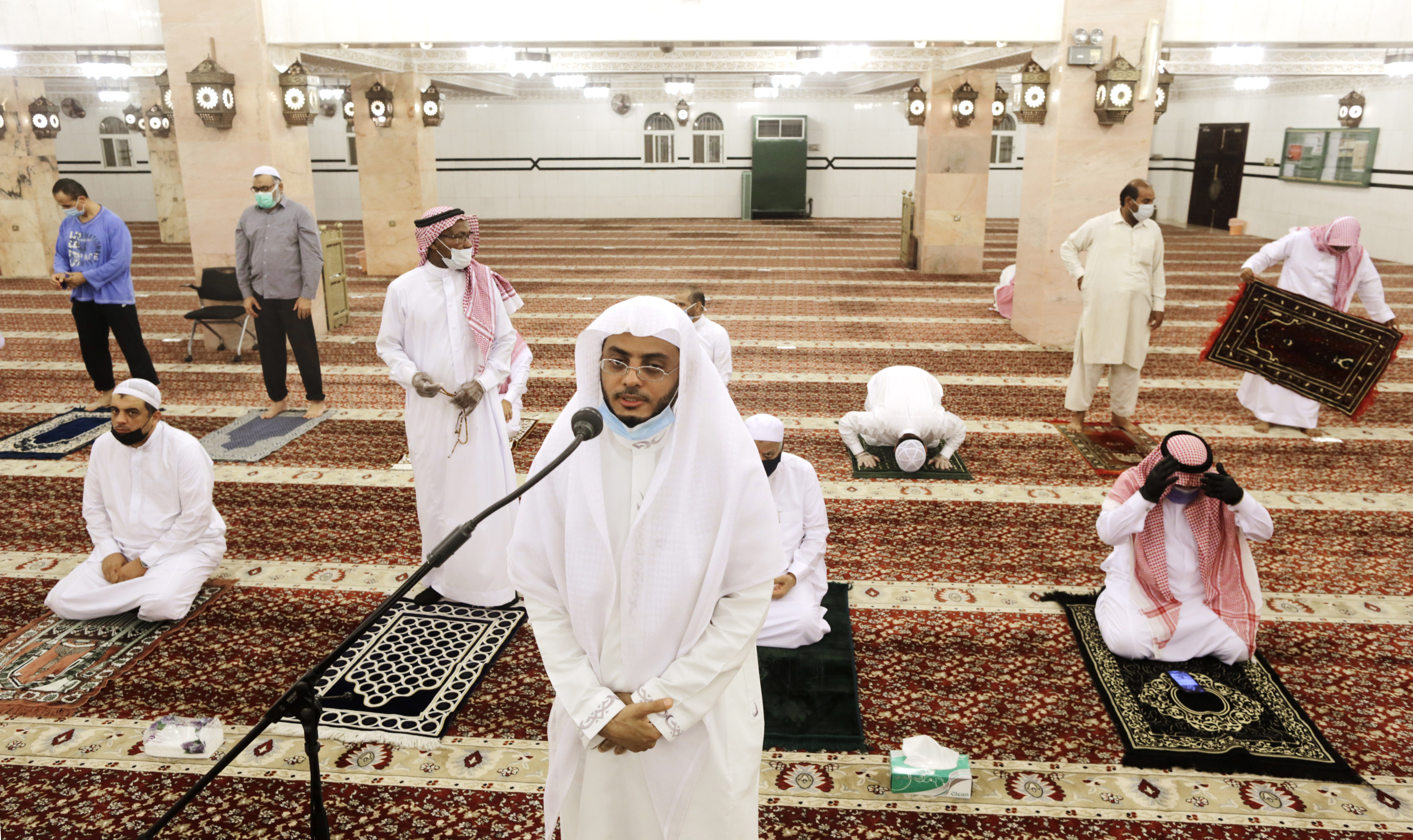 Saudi cleric Hammoud Al-Labban recites the call to prayers as worshippers wearing face masks and observing social distancing guidelines to protect against the new coronavirus, attend dawn prayers at al-Mirabi Mosque in Jiddah, Saudi Arabia, Sunday, May 31, 2020. The Ministry of Islamic Affairs said mosques will open to the public for prayers from May 31 until June 20, except in Mecca, with precautionary measures and instructions. (AP Photo/Amr Nabil)
