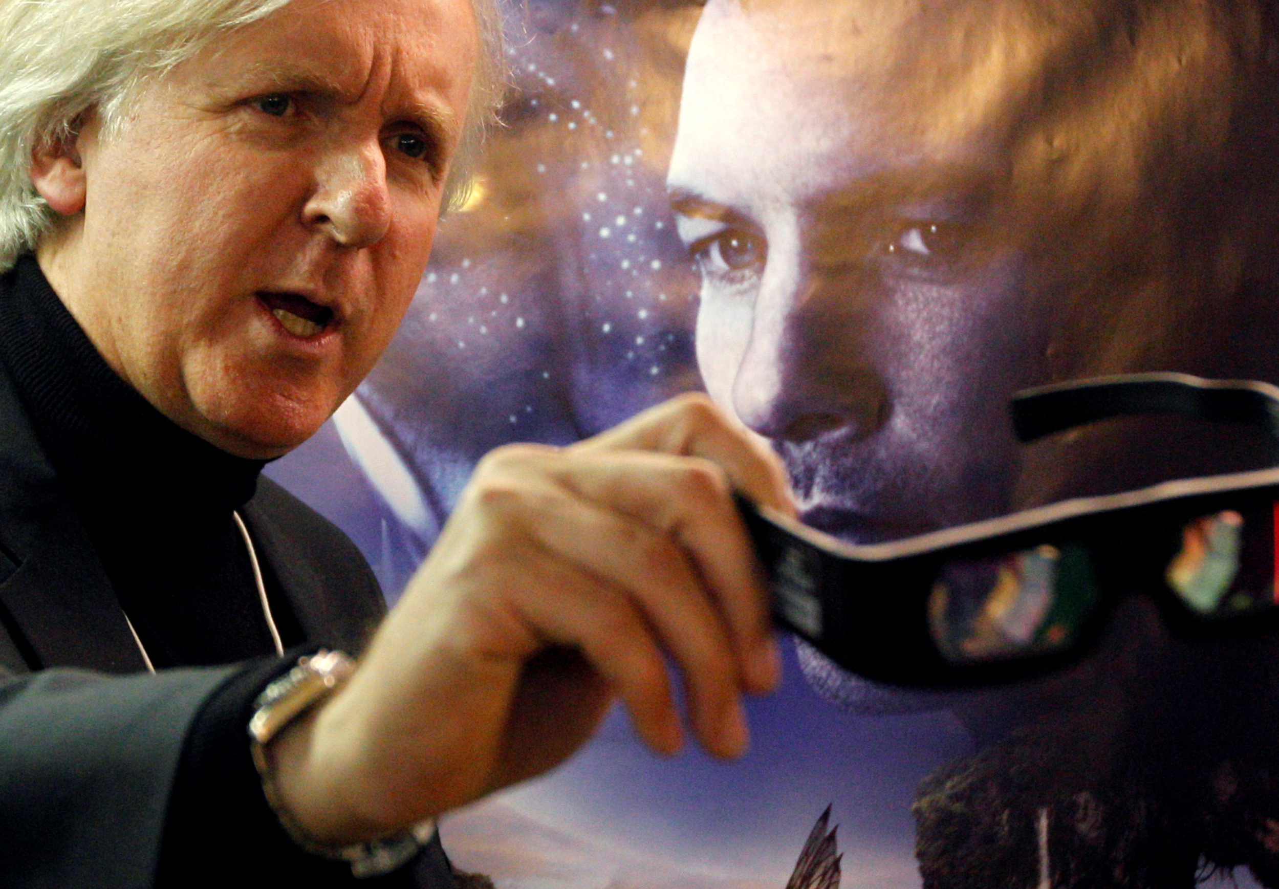 FILE - Canadian director James Cameron shows 3D glasses as he poses in front of a poster before a promotion event for his latest movie Avatar at the World Economic Forum (WEF), in Davos, on  January 28, 2010. Photo: Reuters