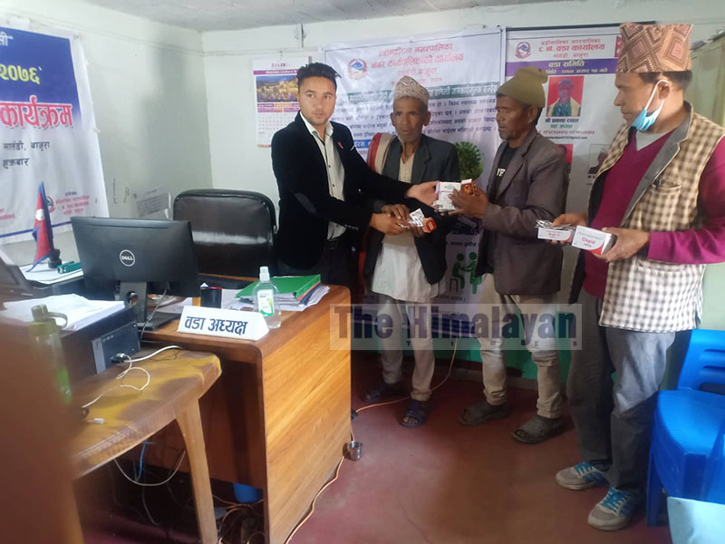 Ward Chairman of Badimalika Municipality, Bajura, Prakash Rawal handing over medicines provided by the municipality to patients with chronic illness, on Monday, May 18, 2020. Photo: THT
