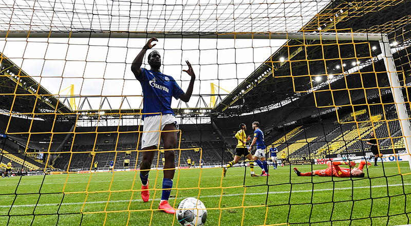 Schalke's Salif Sane reacts in the goal after Dortmund's Raphael Guerreiro scored his side's second goal against Schalke's goalkeeper Markus Schubert, right, as play resumes behind closed doors following the outbreak of the coronavirus disease (COVID-19) during the Bundesliga match at,  Signal Iduna Park, in Dortmund, Germany, on May 16, 2020. Photo: Martin Meissner/Pool via Reuters