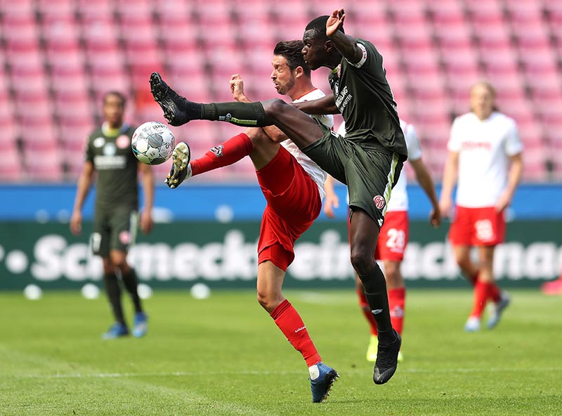 FC Cologne's Mark Uth in action with FSV Mainz 05's Moussa Niakhate, as play resumes behind closed doors following the outbreak of the coronavirus disease (COVID-19) during the  Bundesliga match at RheinEnergieStadion, in Cologne, Germany, on  May 17, 2020. Photo: Lars Baron/Pool via Reuters