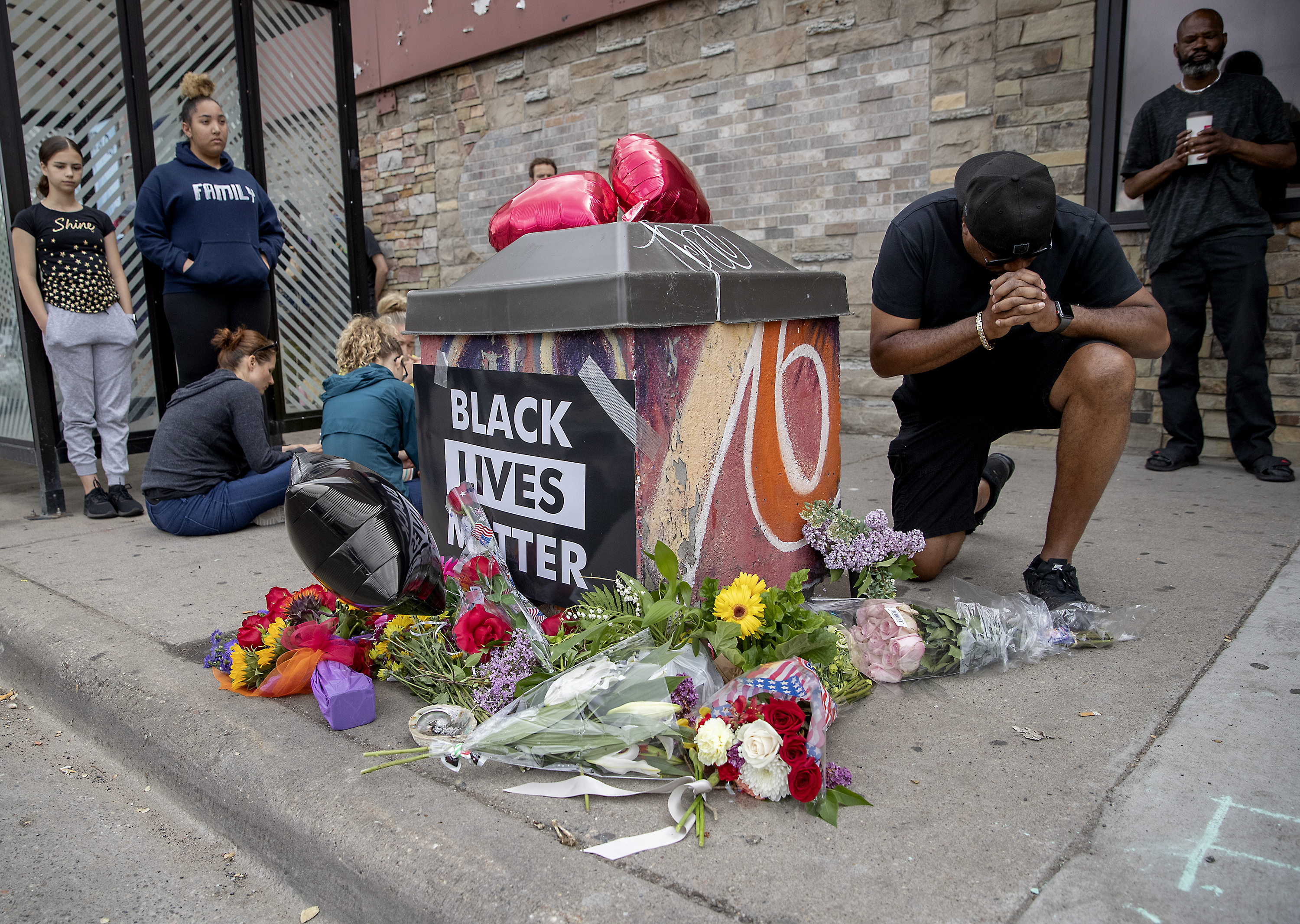 People gather and pray around a makeshift memorial, Tuesday, May 26, 2020, in Minneapolis, near the site where a black man, who was taken into police custody the day before, later died. The FBI and Minnesota agents are investigating the death of a black man in Minneapolis police custody after video from a bystander showed a white officer kneeling on his neck during his arrest as he pleaded that he couldn't breathe.  n Photo: Elizabeth Flores/Star Tribune via AP