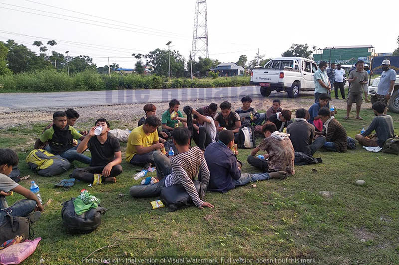 Youths sit near the roadside after arriving from India, in Nawalpur district, on Wednesday, May 13, 2020. Photo: Shreeram Sigdel/THT