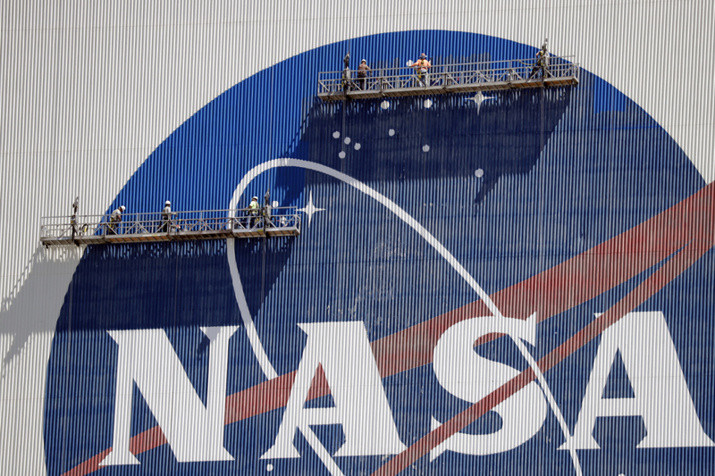 Workers near the top of the 526 ft Vehicle Assembly Building at the Kennedy Space Center spruce up the NASA logo standing on scaffolds in Cape Canaveral, Florida, Wednesday, May 20, 2020. Photo: AP