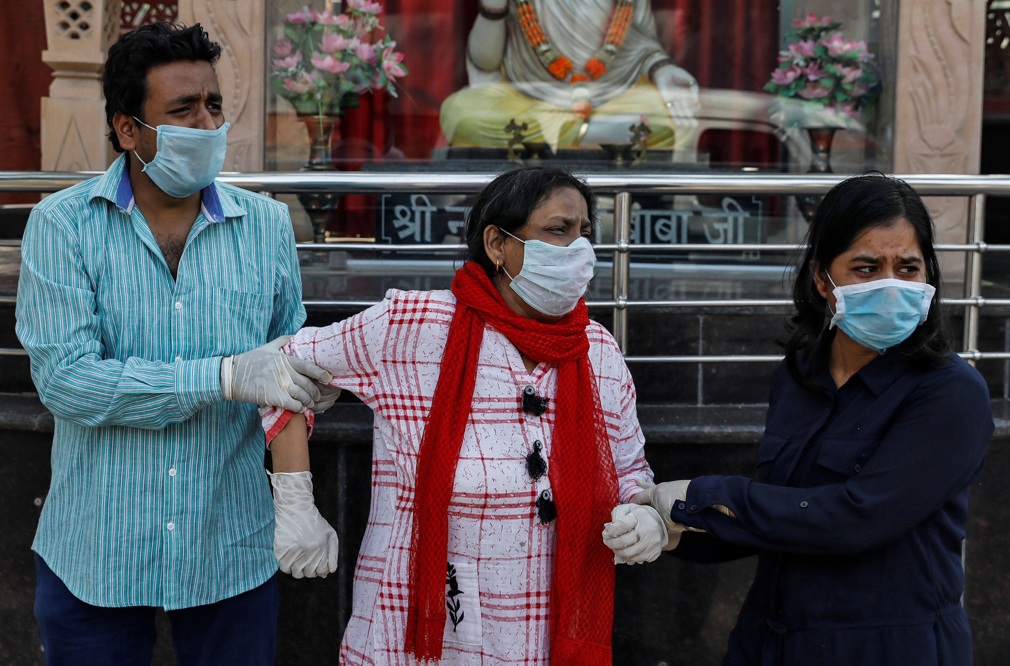Family members of Virendra Gupta, who died due to the coronavirus disease (COVID-19), wear protective masks and gloves as they mourn during his cremation at the Nigambodh Ghat crematorium in New Delhi, India, June 1, 2020. Photo: Reuters