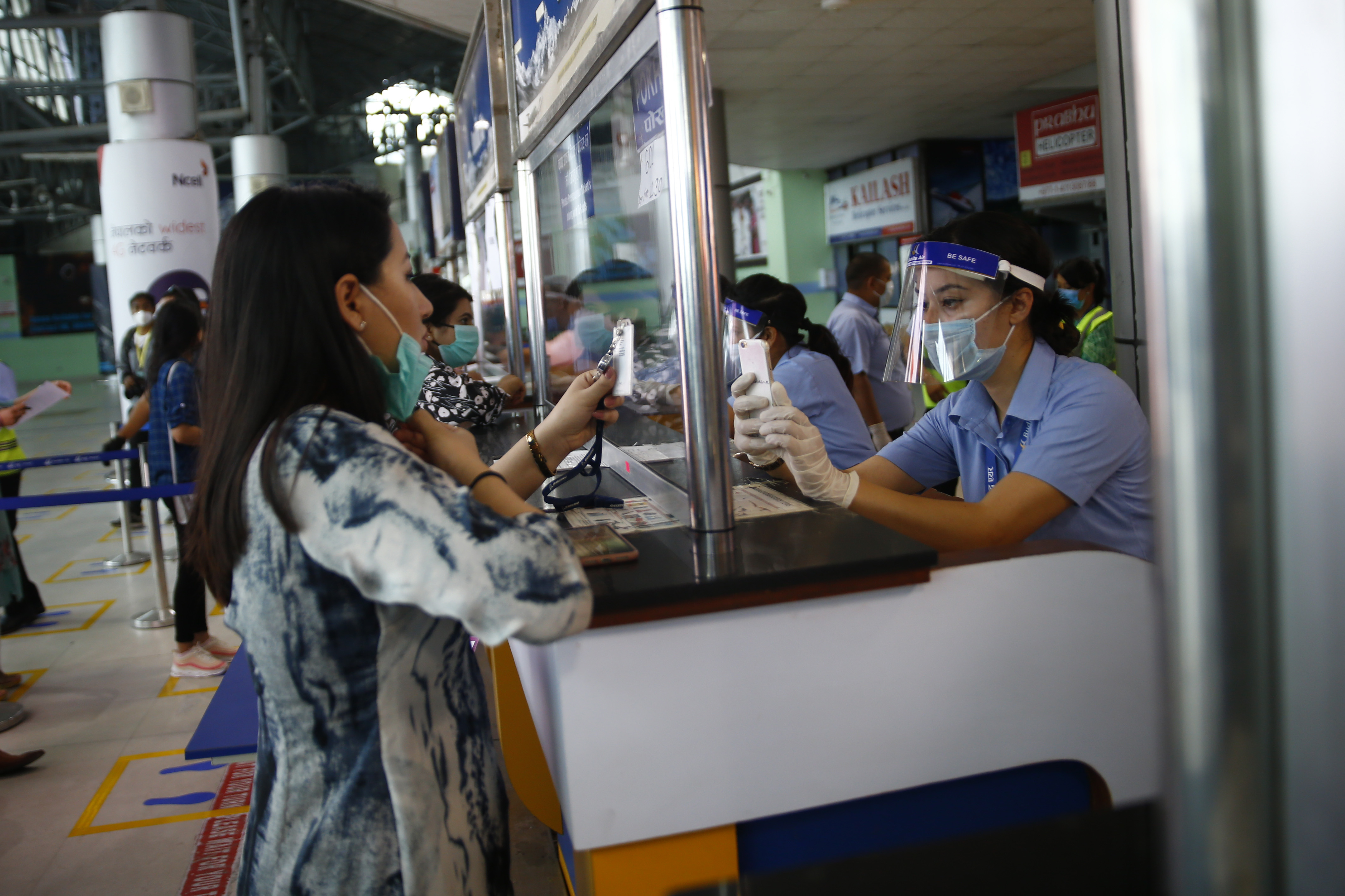 Passengers of Buddha Air show their flight tickets at the counter during a mock drill to make necessary preparations for the resumption of domestic and international flights starting August 1 as Nepal has suspended all passenger flights enforcing the lockdown to contain the spread of coronavirus disease at Tribhuvan International Airport in Kathmandu, Nepal on Thursday, June 25, 2020.