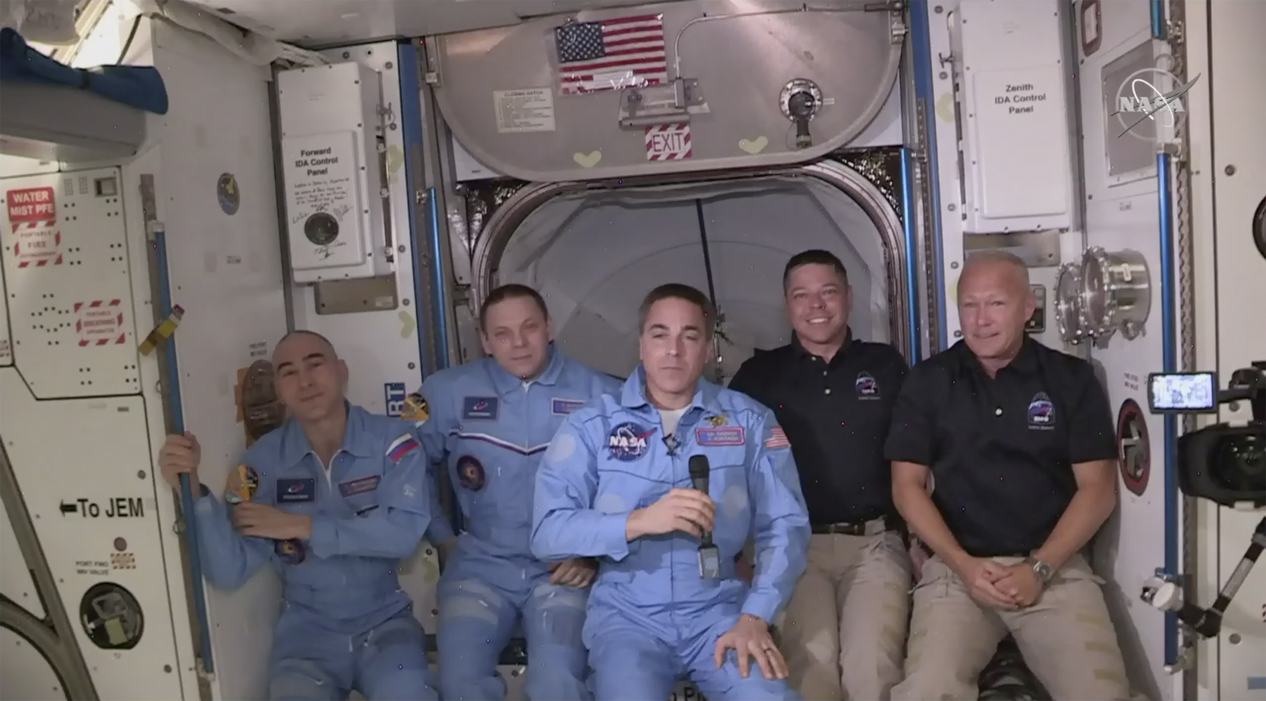 This photo provided by NASA shows Bob Behnken and Doug Hurley, far right, joining the the crew at the International Space Station, after the SpaceX Dragon capsule pulled up to the station and docked Sunday, May 31, 2020.  The Dragon capsule arrived Sunday morning, hours after a historic liftoff from Florida. It's the first time that a privately built and owned spacecraft has delivered a crew to the orbiting lab.(NASA via AP)