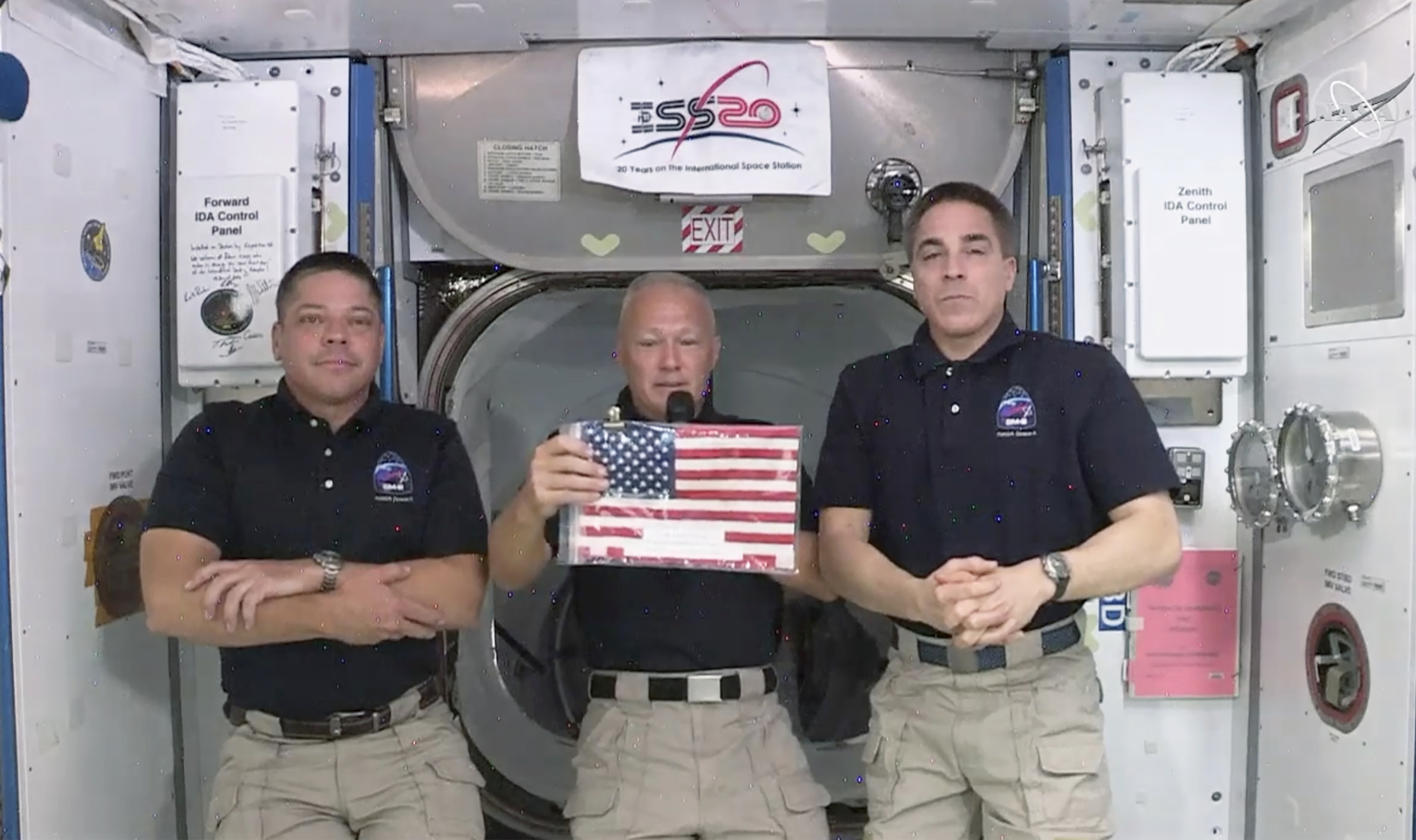 In this image taken from NASA video on Monday, June 1, 2020, NASA astronauts Robert L. Behnken, left, and Chris Cassidy right, listen as commander Douglas Hurley speaks about retrieving the American flag left behind at the International Space Station nearly a decade ago. Photo: AP
