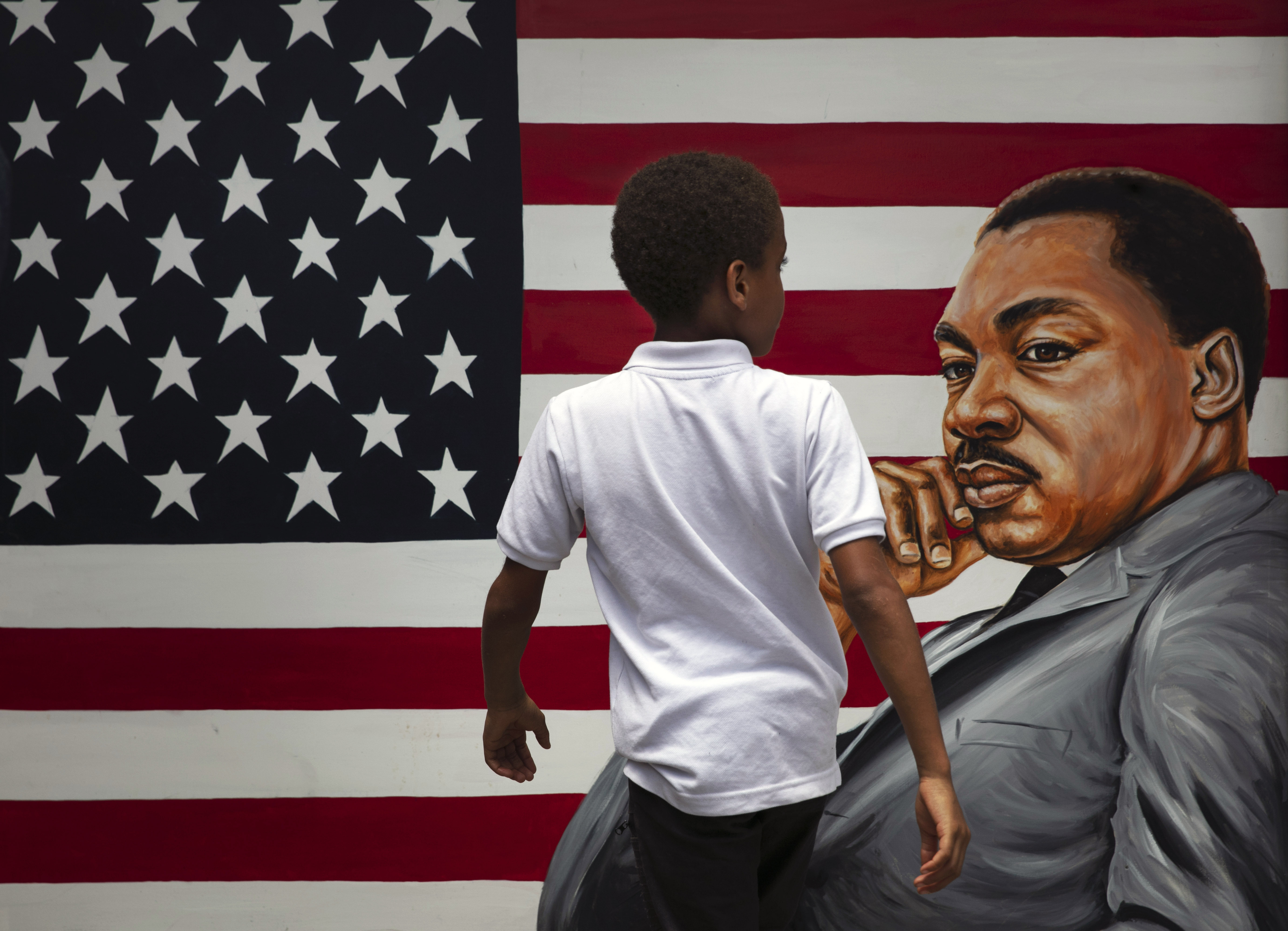 A young boy walks past a painting depicting Dr. Martin Luther King Jr. during a Juneteenth celebration in Los Angeles. Friday, June 19, 2020. Juneteenth marks the day in 1865 when federal troops arrived in Galveston, Texas, to take control of the state and ensure all enslaved people be freed, more than two years after the Emancipation Proclamation. Photo: AP