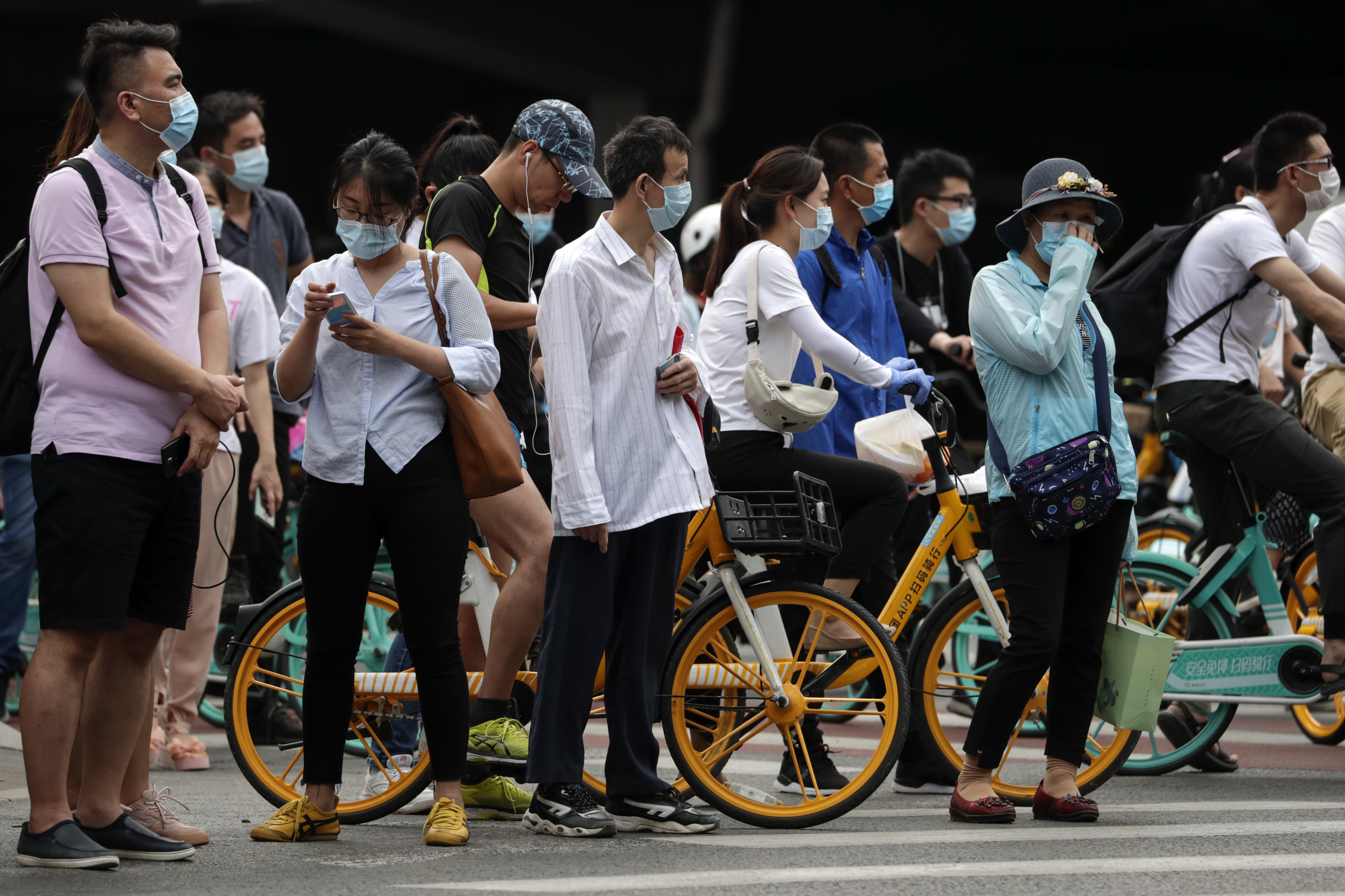 People wearing protective face masks to help curb the spread of the new coronavirus wait to cross a street in Beijing, Monday, June 22, 2020. A Beijing government spokesperson said the city has contained the momentum of a recent coronavirus outbreak that has infected a few hundreds of people, after the number of daily new cases fell to single digits. Photo: AP