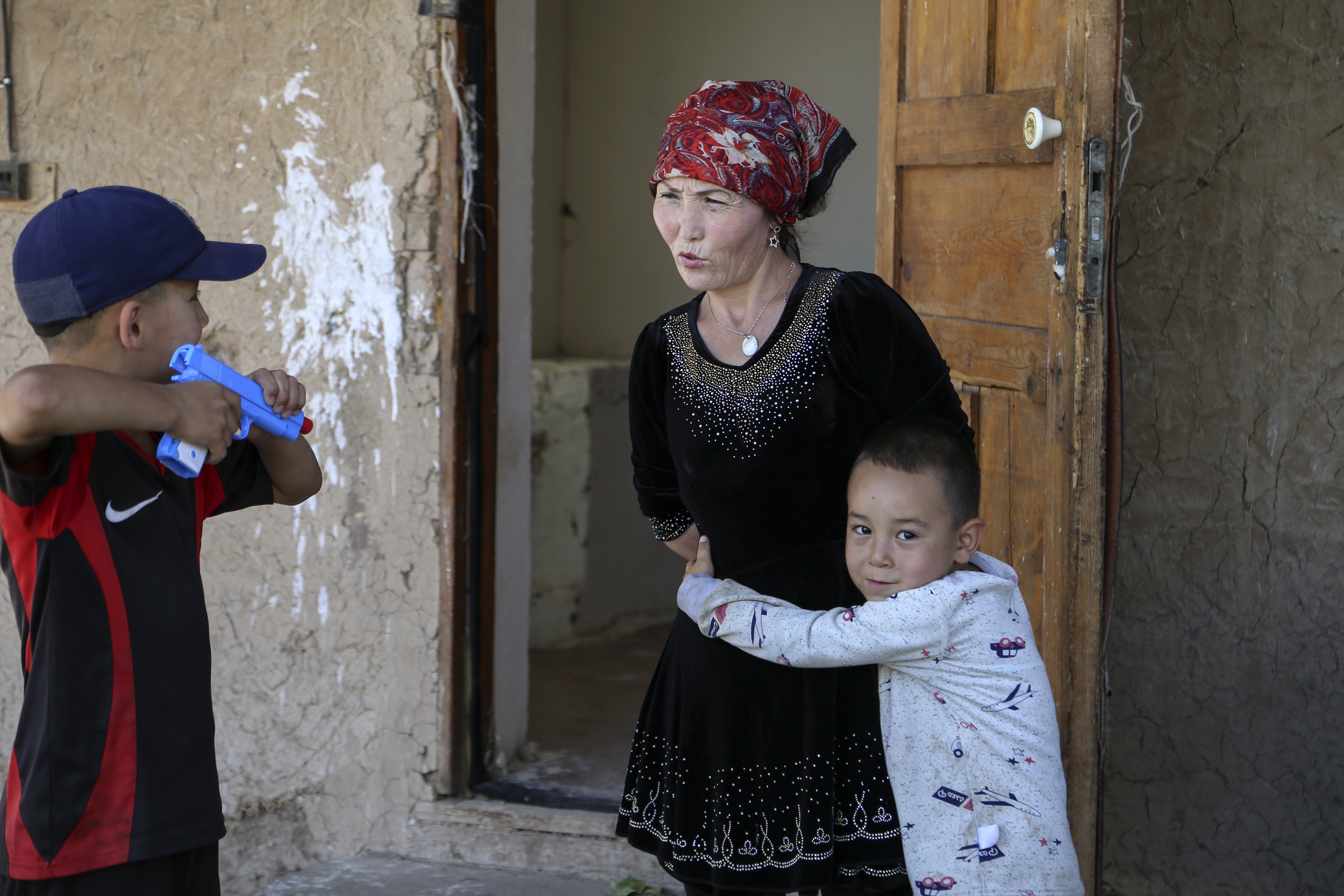 Alif Baqytali hugs his mother, Gulnar Omirzakh, at their new home in Shonzhy, Kazakhstan. Omirzakh, a Chinese-born ethnic Kazakh, says she was forced to get an intrauterine contraceptive device, and that authorities in China threatened to detain her if she didn't pay a large fine for giving birth to Alif, her third child. Photo: AP