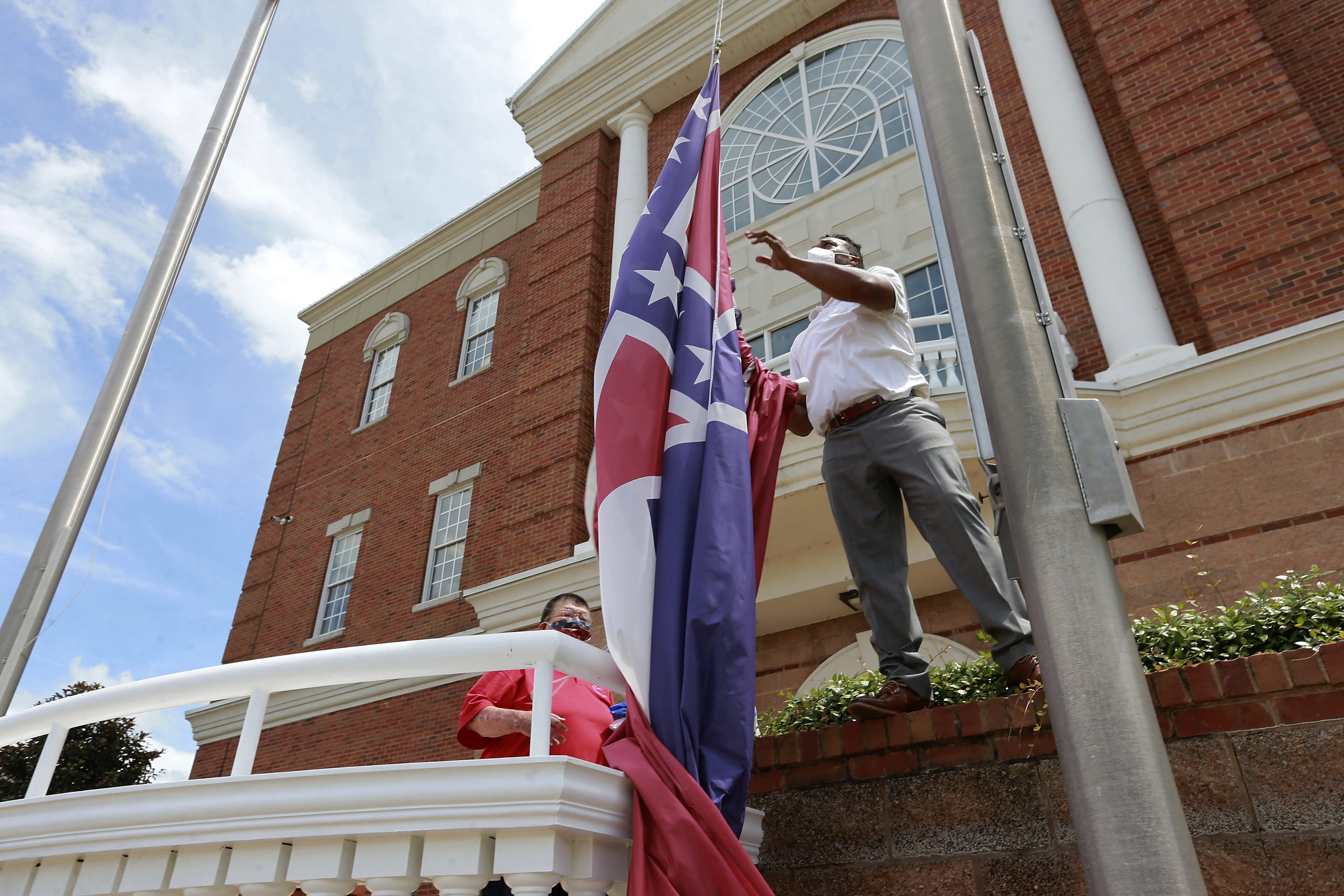 FILE - In this Monday, June 29, 2020, file photo, City of Tupelo Community Outreach Coordinator Marcus Gary takes down the Mississippi state flag that flew over the City Hall of Tupelo one last time Monday, June 29, 2020. Mississippi is retiring the last state flag in the U.S. that includes the Confederate battle emblem. Photo: AP