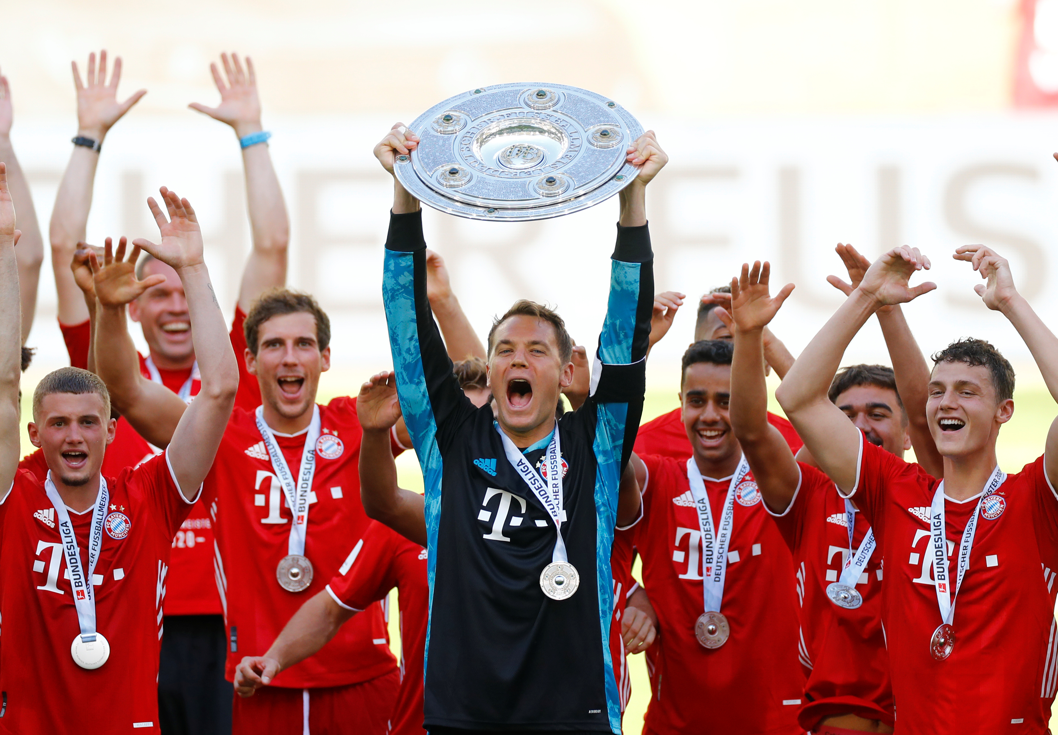 Bayern Munich's Manuel Neuer celebrates with the trophy and teammates after winning the Bundesliga, following the resumption of play behind closed doors after the outbreak of the coronavirus disease (COVID-19) during the  Bundesliga match between VfL Wolfsburg and Bayern Munich, at  Volkswagen Arena, in Wolfsburg, Germany, on June 27, 2020. Photo: Reuters