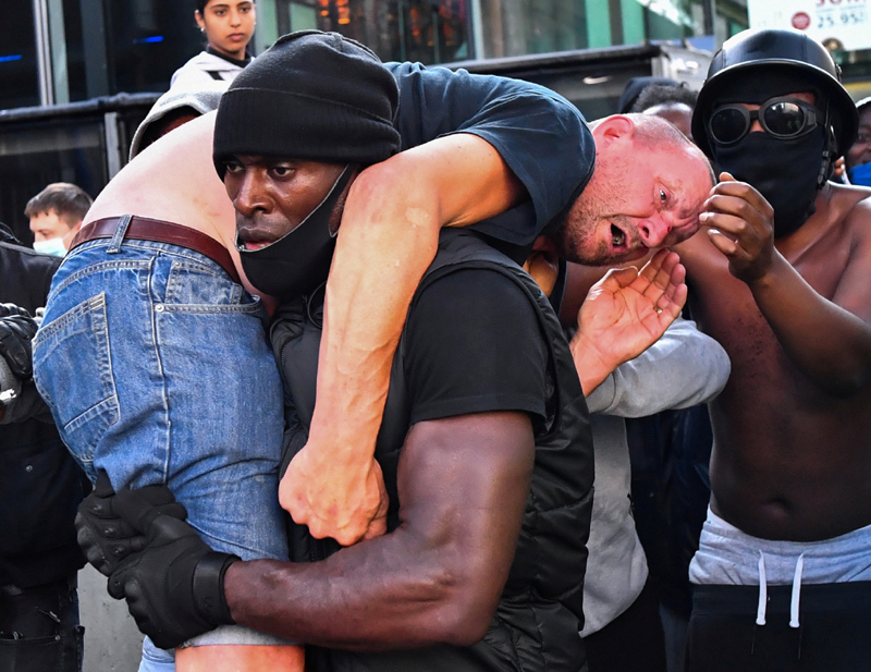 A protester carries an injured counter-protester to safety, near the Waterloo station during a Black Lives Matter protest following the death of George Floyd in Minneapolis police custody, in London, Britain, June 13, 2020. Photo: Reuters