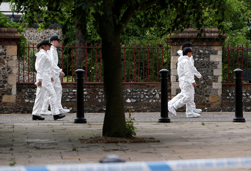 Police officers in forensic suits walk along the park where the scene of multiple stabbings took place, in Reading, Britain June 21, 2020. Photo: Reuters