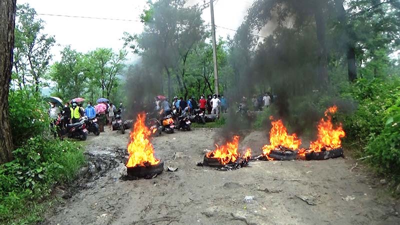 Local residents burn tyres on the road at Lameahal in Pokhara Metropolis, Kaski district, on Thursday, June 25, 2020. Locals protested as authorities prepared to bury the body of a person infected with COVID-19 on the bank of Seti River, at Majuwa, Pokhara, on Thursday. Photo: Bharat Koirala/THT