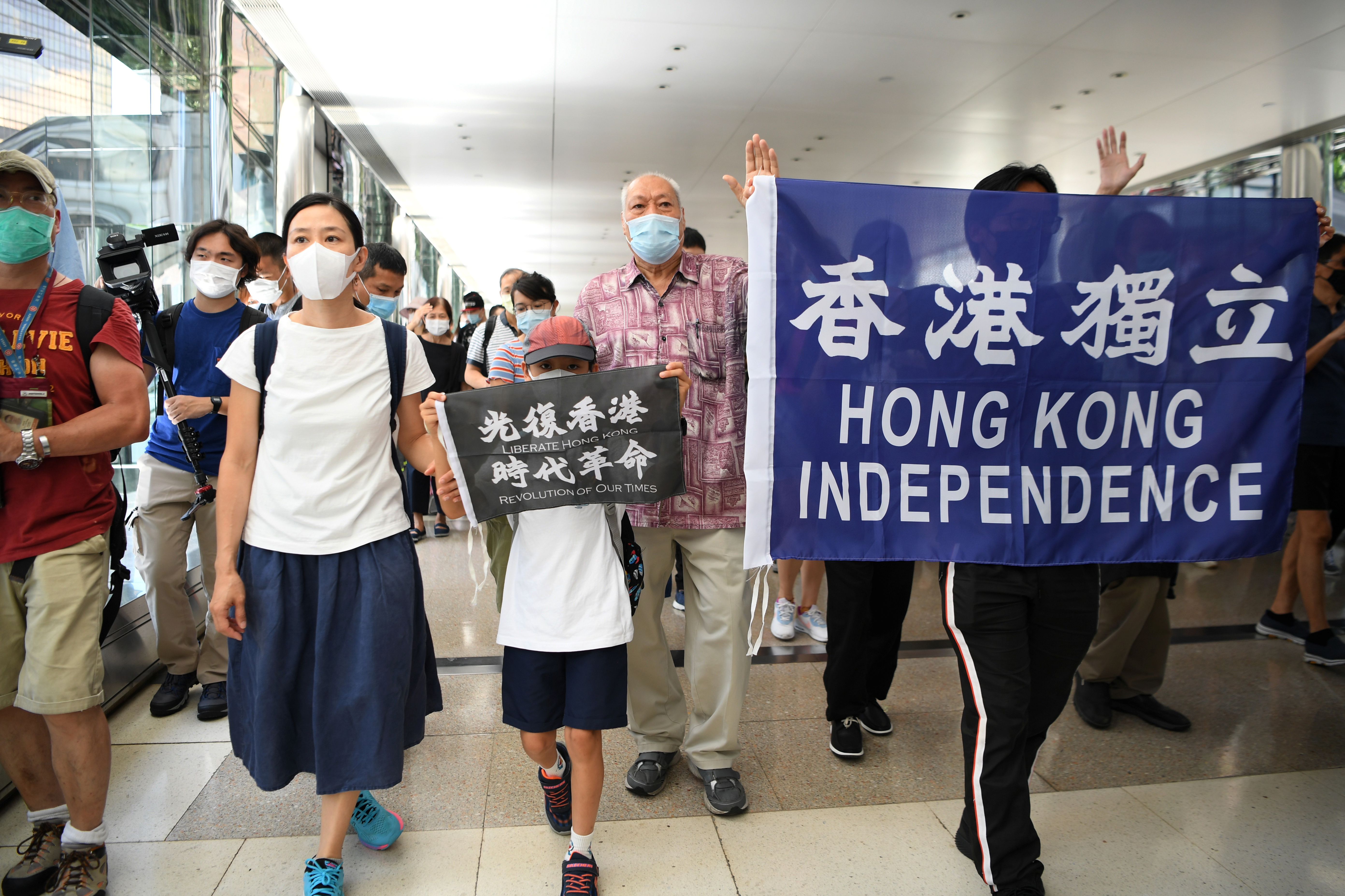 Pro-democracy protesters hold banners as they march during a lunchtime demonstration at the Pacific Place mall in Hong Kong, China June 12, 2020. REUTERS/Laurel Chor