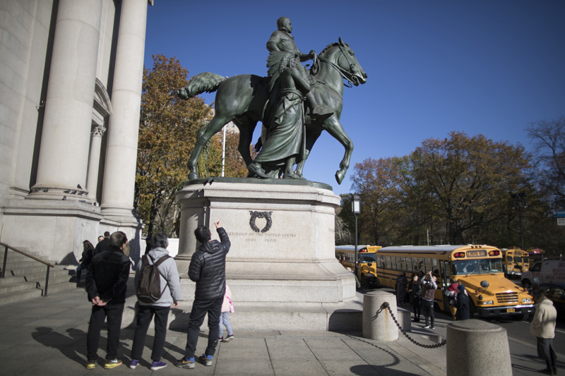 Visitors to the American Museum of Natural History in New York look at a statue of Theodore Roosevelt, flanked by a Native American man and African American man, Nov. 17, 2017. Photo: AP/File