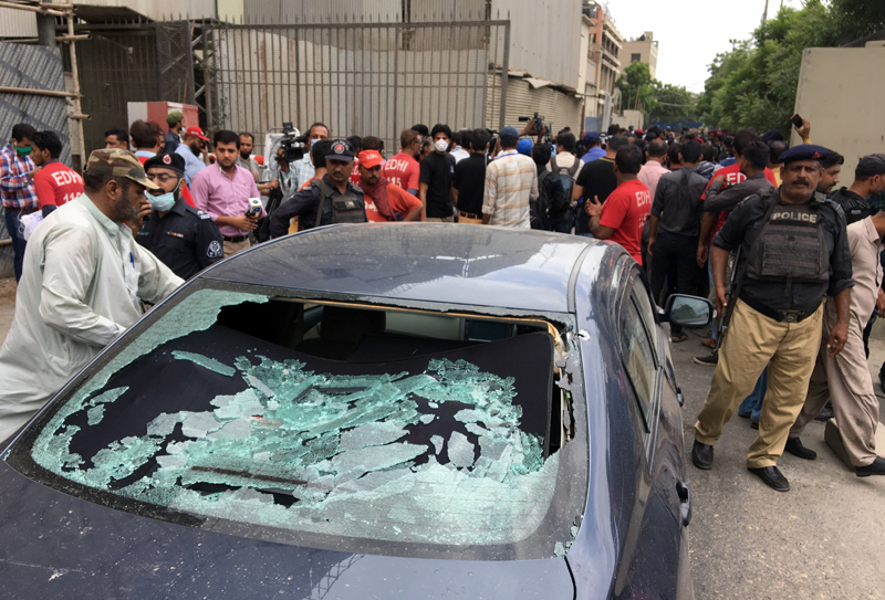 A plainclothes police officer (L) surveys the site of an attack at the Pakistan Stocks Exchange entrance in Karachi June 29, 2020. Photo: Reuters