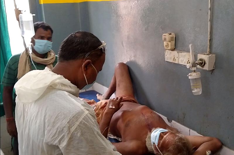 This image shows two men looking after an injured man receiving treatment at Gajendra Narayan Singh Hospital, Rajbiraj in Saptari district, on Wednesday, June 3, 2020. As many as 15 persons were injured in a clash that erupted in a land dispute between to persons at Hati Tole in Chhinnamasta Rural Municipality.  Photo: Byas Shankar Upadhyay/THT 