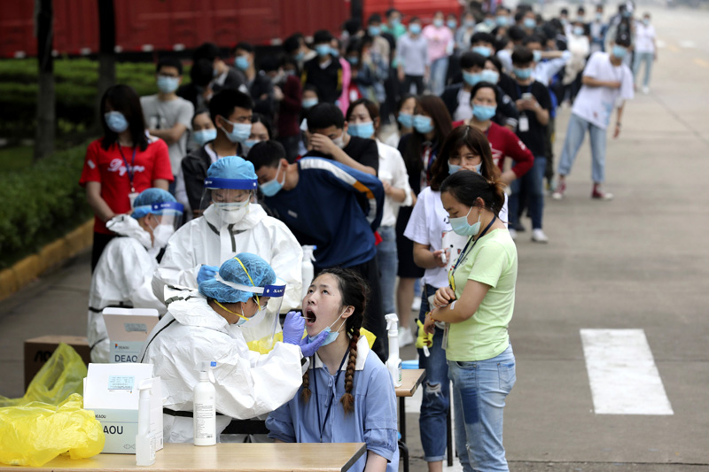 People line up for medical workers to take swabs for the coronavirus test at a large factory in Wuhan in central China's Hubei province, May 15, 2020. Photo: Chinatopix Via AP