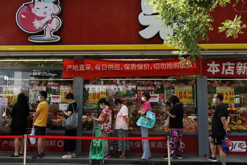 People wearing face masks line up outside a food store following a new outbreak of the coronavirus disease (COVID-19), in Fengtai district of Beijing, China, June 19, 2020.  Photo: Reuters