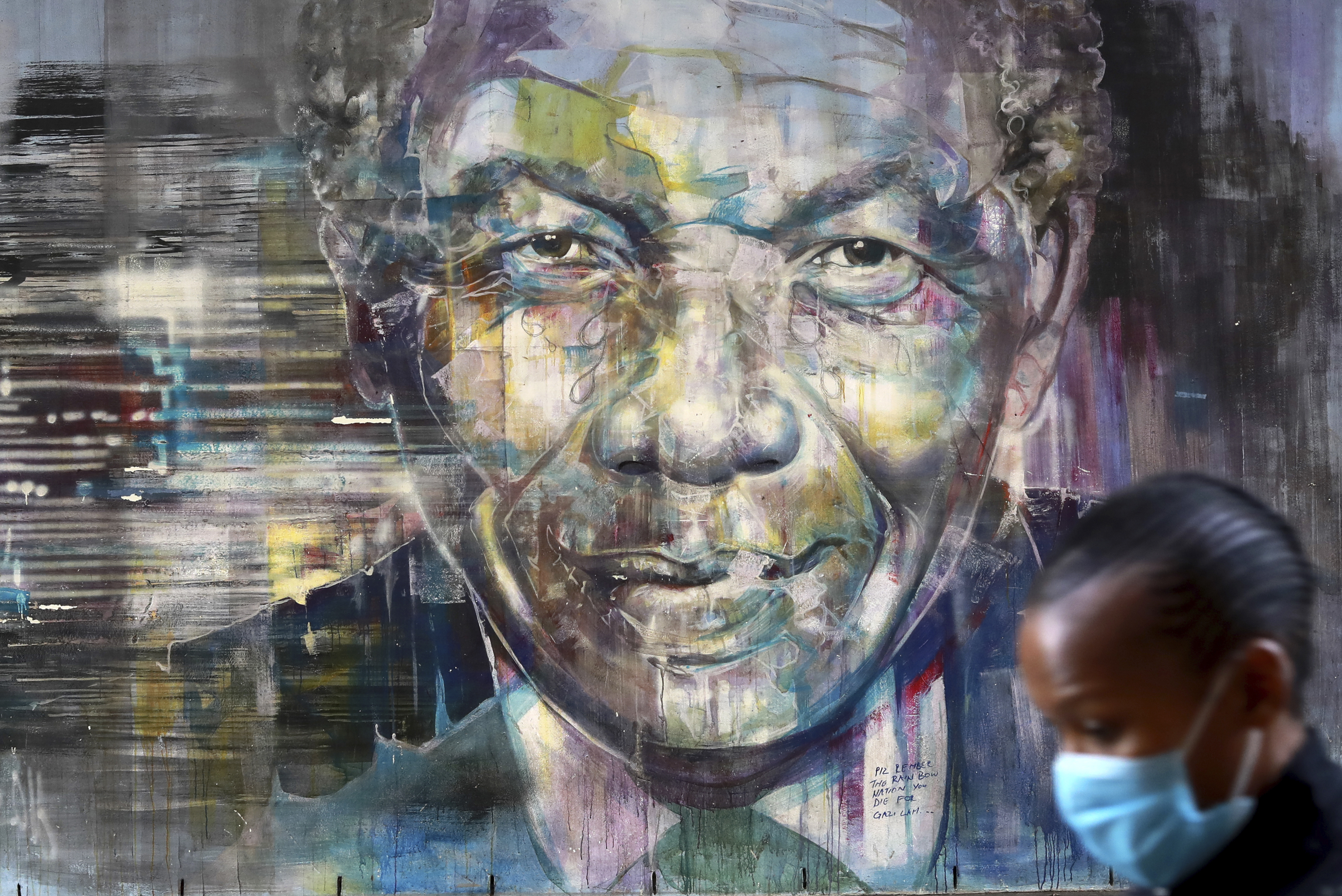 A woman wearing a face mask walks past a mural of former President Nelson Mandela in Cape Town, South Africa, Saturday July 18, 2020, as the country celebrates International Mandela Day. Mandela's fight for freedom and human rights makes him the most influential person among Africa's youth, according to a survey conducted across the continent. Photo: AP