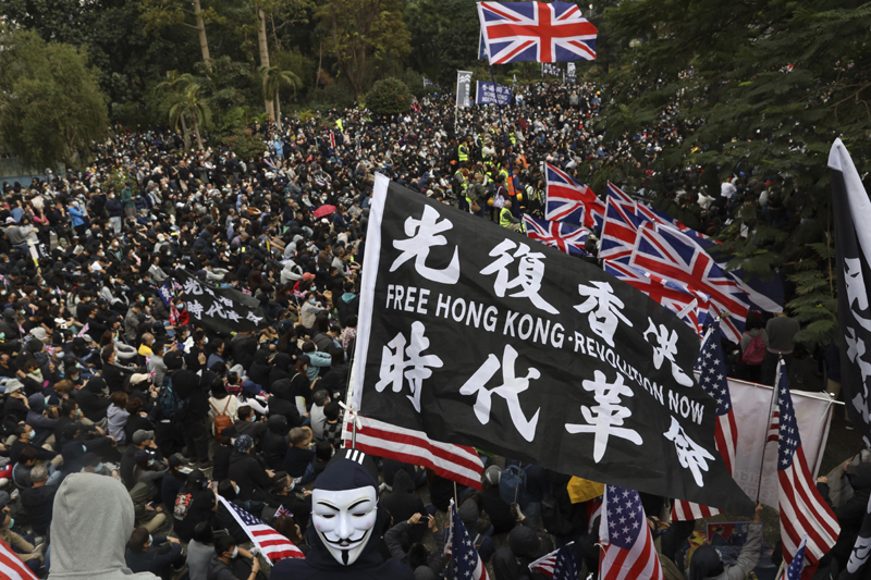 In this Sunday, Jan. 19, 2020 file photo, participants wave British and U.S. flags during a rally demanding electoral democracy and call for boycott of the Chinese Communist Party and all businesses seen to support it in Hong Kong. Photo: AP/file
