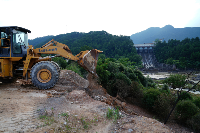 A front loader unloads rocks and soil to reinforce the banks of Gantang river near the Qingshitan reservoir in Lingchuan county, Guangxi Zhuang Autonomous Region, China July 17, 2020. Photo: Reuters
