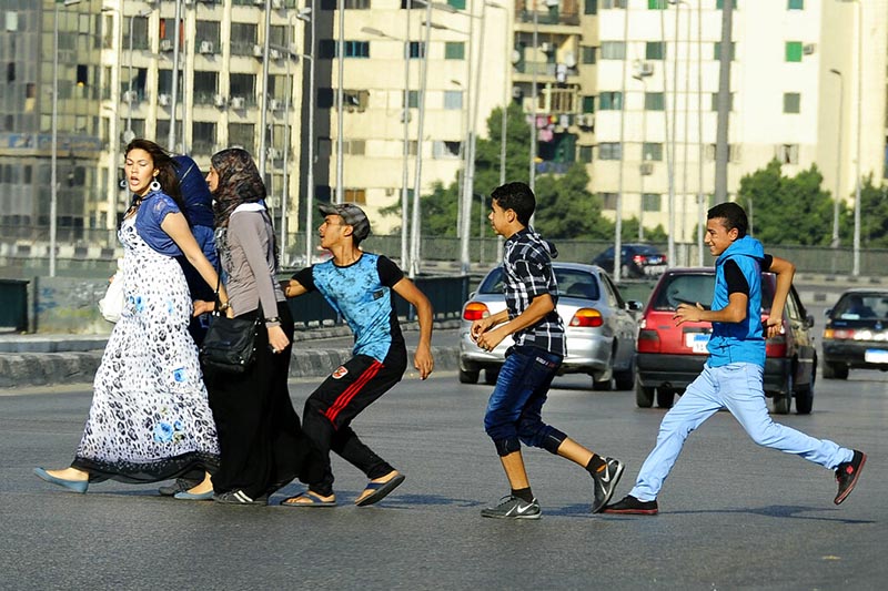 FILE - An Egyptian youth, trailed by his friends, gropes a woman crossing the street with her friends in Cairo, Egypt, on August 20, 2012. Photo: AP