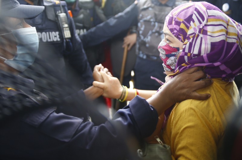 A woman tussles with a security personnel before being arrested, during a protest demanding that government honour the recently struck 12-point deal with Satyagrahis, near the Prime Minister's official residence, in Baluwatar, Kathmandu, on Friday, July 31, 2020. Photo: Skanda Gautam/THT