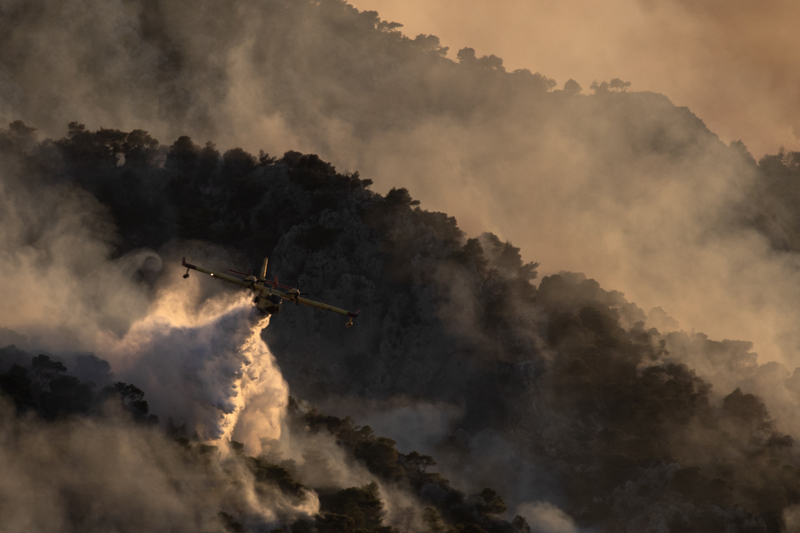 A firefighting airplane drops water on a hill near the area of Kehries, near Corinth, 80 kilometers (50 miles) southwest of Athens, on Thursday July 23, 2020. Photo: AP