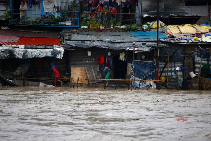 People negotiating their way through floodwaters that inundated their shanty town area after heavy rainfall.