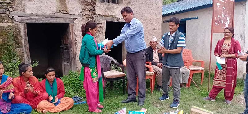 Chairman of Khaptadchhedaha Rural Municipality Nar Bahadur Rawat distributing health materials among youths, in Bajura, on Wednesday, July 1, 2020. Photo: THT