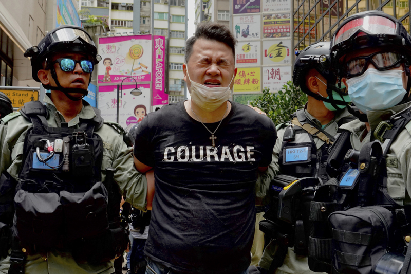 Police detain a protester after spraying pepper spray during a protest in Causeway Bay before the annual handover march in Hong Kong, Wednesday, July. 1, 2020. Photo: AP