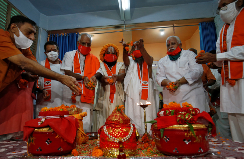 Hindu priests and supporters of the Vishva Hindu Parishad (VHP), a Hindu nationalist organisation, perform rituals next to pots filled with holy water and soil which they brought from various Hindu religious places, before taking the pots to the northern town of Ayodhya for a stone laying ceremony in the Ram Temple, in Ahmedabad, India July 27, 2020. Photo: Reuters