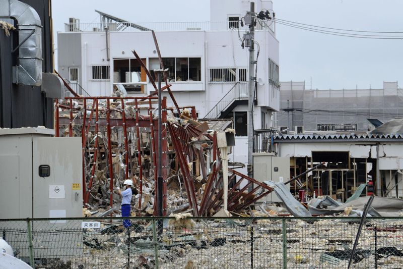 An investigator stands in front of a damaged building following an explosion in Koriyama, Fukushima prefecture, northern Japan Thursday, July 30, 2020. Photo: Kyodo News via AP