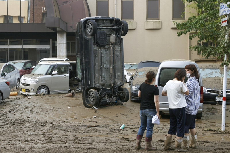 A car stands vertically on a muddy road after being washed away by flood, in Hitoyoshi, Kumamoto prefecture, southwestern Japan, Sunday, July 5, 2020. Heavy rain in the Kumamoto region triggered flooding and mudslides Saturday and left dozens still being stranded at their homes and other facilities. Photo: Kyodo News via AP