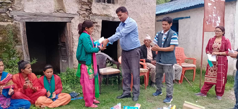 Chair of Khaptad Chhededaha Rural Municipality, Nar Bahadur Rawat, distributing health materials to girls and boys, on Wednesday, July 01, 2020. Photo: Prakash Singh/THT
