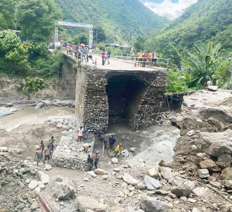 Workers building gabions on the Mauwa River bed in Dhading district on Wednesday, July 23, 2020. The part of the bridge over Mauwa River was swept away by flood on July 20. Photo: Keshav Adikari/THT