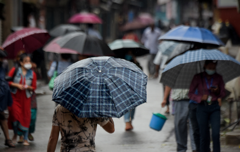 People walk down the street with their umbrellas while it rains in Lalitpur, on Friday, July 10, 2020. Photo: Naresh Shrestha/THT