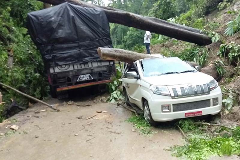 A truck and a car come under trees fallen together with landslide debris along the East-West Highway in Daunne, Binayi Triveni Rural Municipality-2 of Nawalpur district, on Tuesday, July 14, 2020. Photo: Shreeram Sigdel