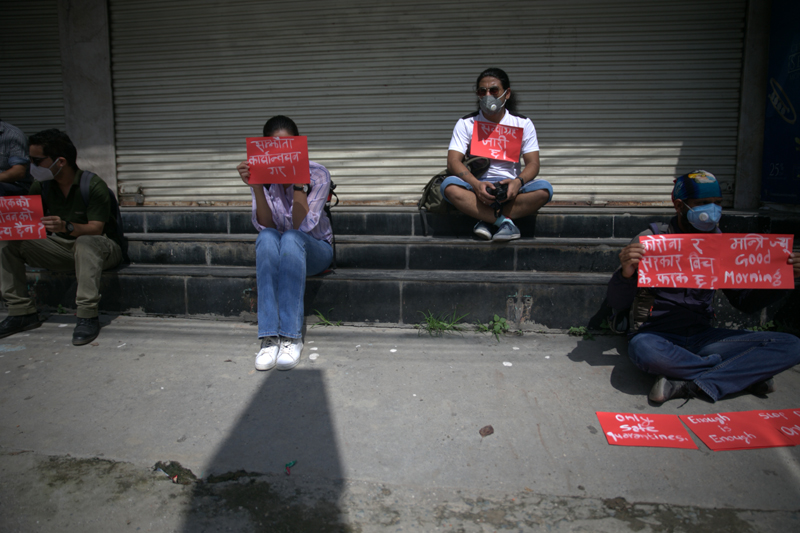 Youths hold placards during a protest to hold the concerned ministers accountable to address the 12-point agreement promised by the government for better COVID-19 response, at Minister's Quarter, in Lalitpur, on Thursday, July 16, 2020. Photo: Skanda Gautam/THT