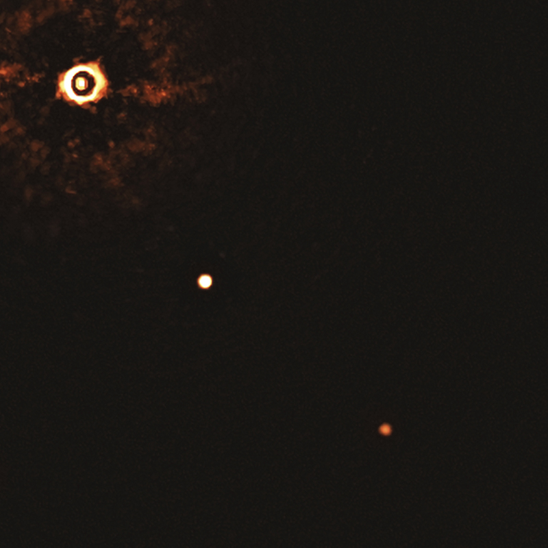 This image made available by the European Southern Observatory in July 2020 shows the star TYC 8998-760-1, upper left, and two giant exoplanets. The image was captured by blocking the light from the young, Sun-like star, allowing for the fainter planets to be detected. The system is about 300 light-years away from Earth. Photo: Bohn et al./ESO via AP