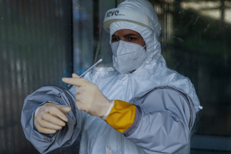 A health worker collects throat swabs for Polymerase Chain Reaction (PCR) testing of patients at Teku-based Sukraraj Tropical and Infectious Disease Hospital, in Kathmandu, on Thursday, July 9, 2020. Photo: Skanda Gautam/THT