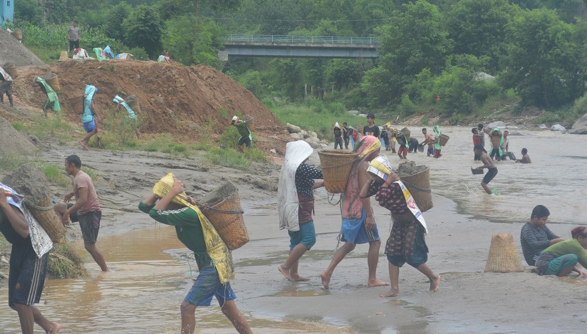Labourers carrying sand taken out from the Trishuli River in bamboo baskets, in Galchhi Rural Municipality, Dhading on Thursday. Photo: THT
