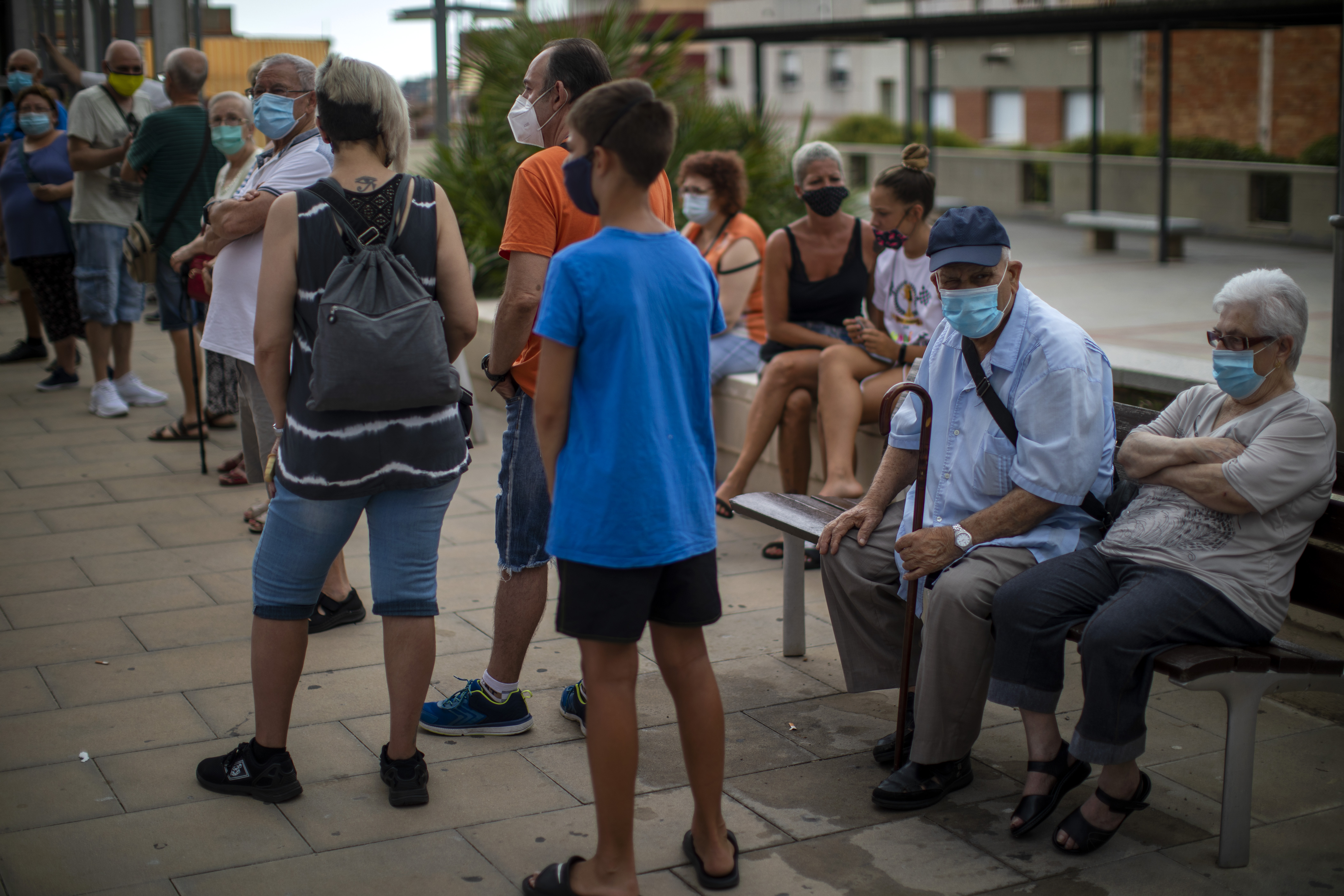 People wearing face masks wait their turn to be called for a PCR test for the COVID-19 outside a local clinic in Santa Coloma de Gramanet in Barcelona, Spain, Tuesday, Aug. 11, 2020. Photo: AP