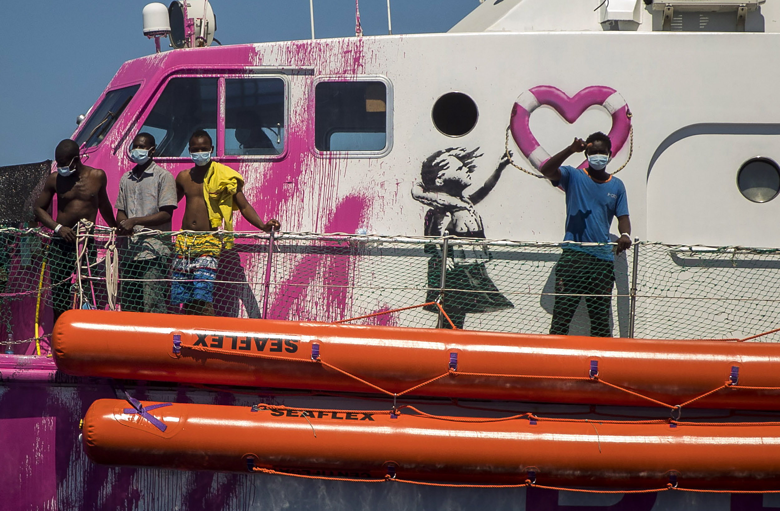 A boy waves to the crew of the Astral rescue vessel from the deck of the Louise Michelu00a0rescue vessel, a French patrol boat currently manned by activists and funded by the renowned artist Banksy in the Central Mediterranean sea, at 50 miles south from Lampedusa, Friday, Aug. 28, 2020. Photo: AP